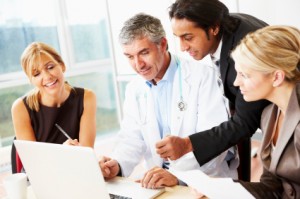 business team looking at laptop with doctor